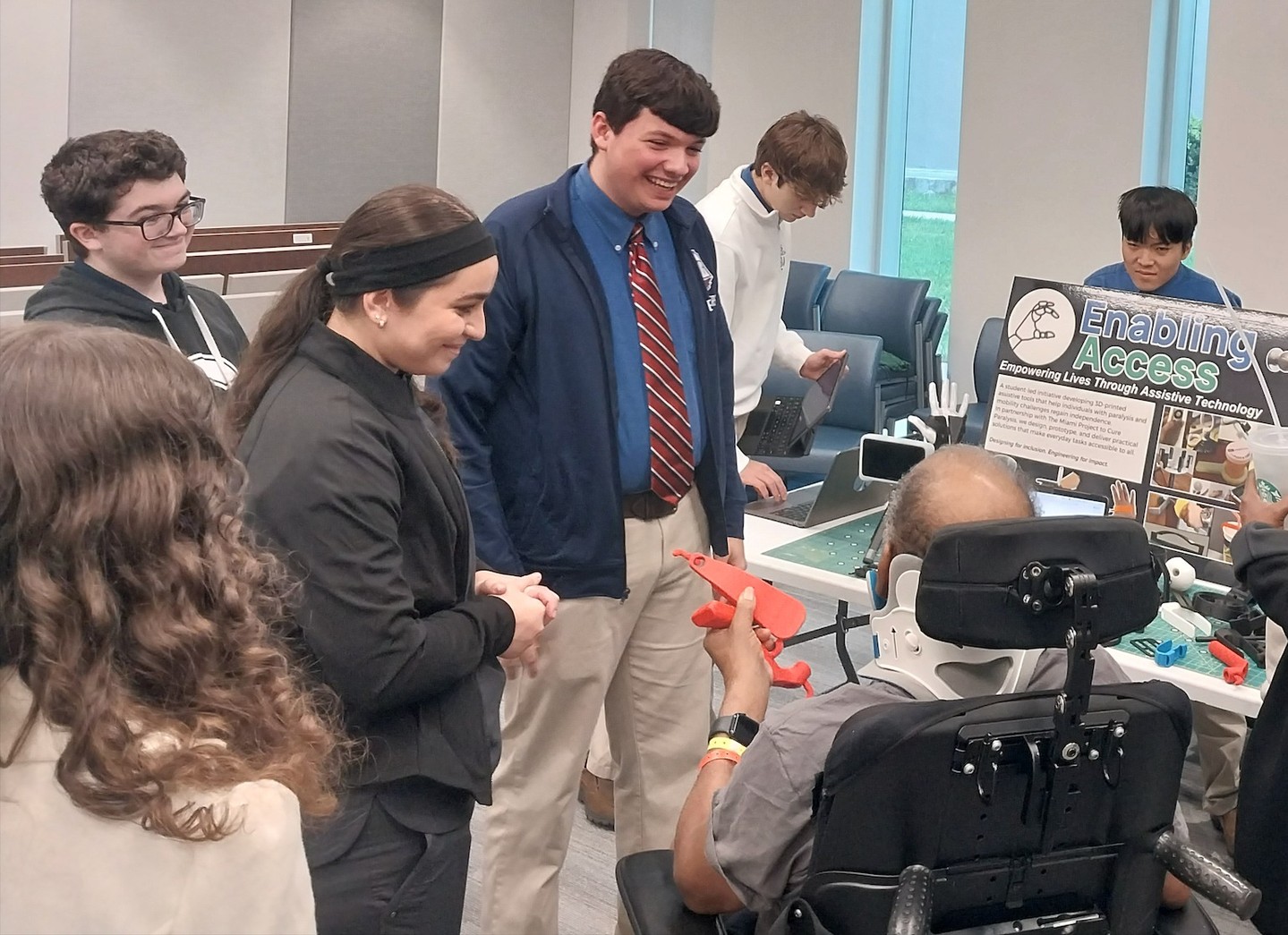 Students presenting 3D-printed assistive devices to patients at the rehabilitation center
